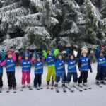 Kinder und Übungsleiter mit Freude im Schnee