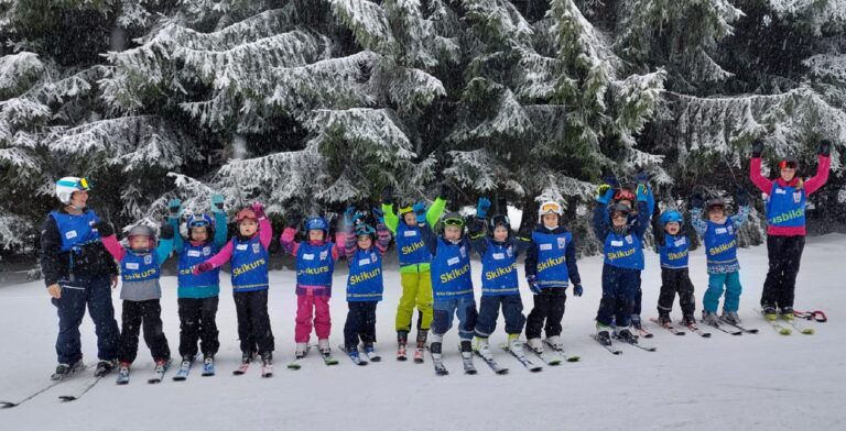 Kinder und Übungsleiter mit Freude im Schnee